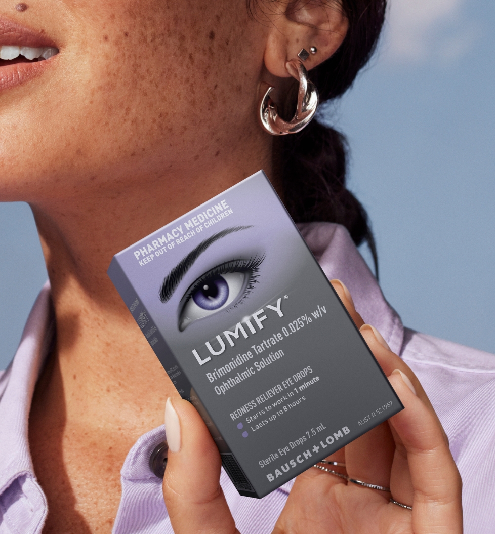 Woman holding a Lumify redness relieving eye drops bottle